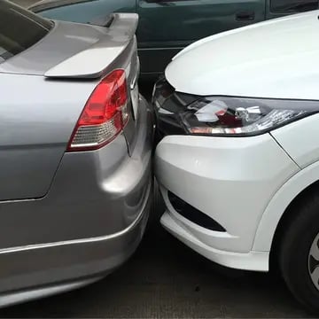 Two cars collided with their bumpers.